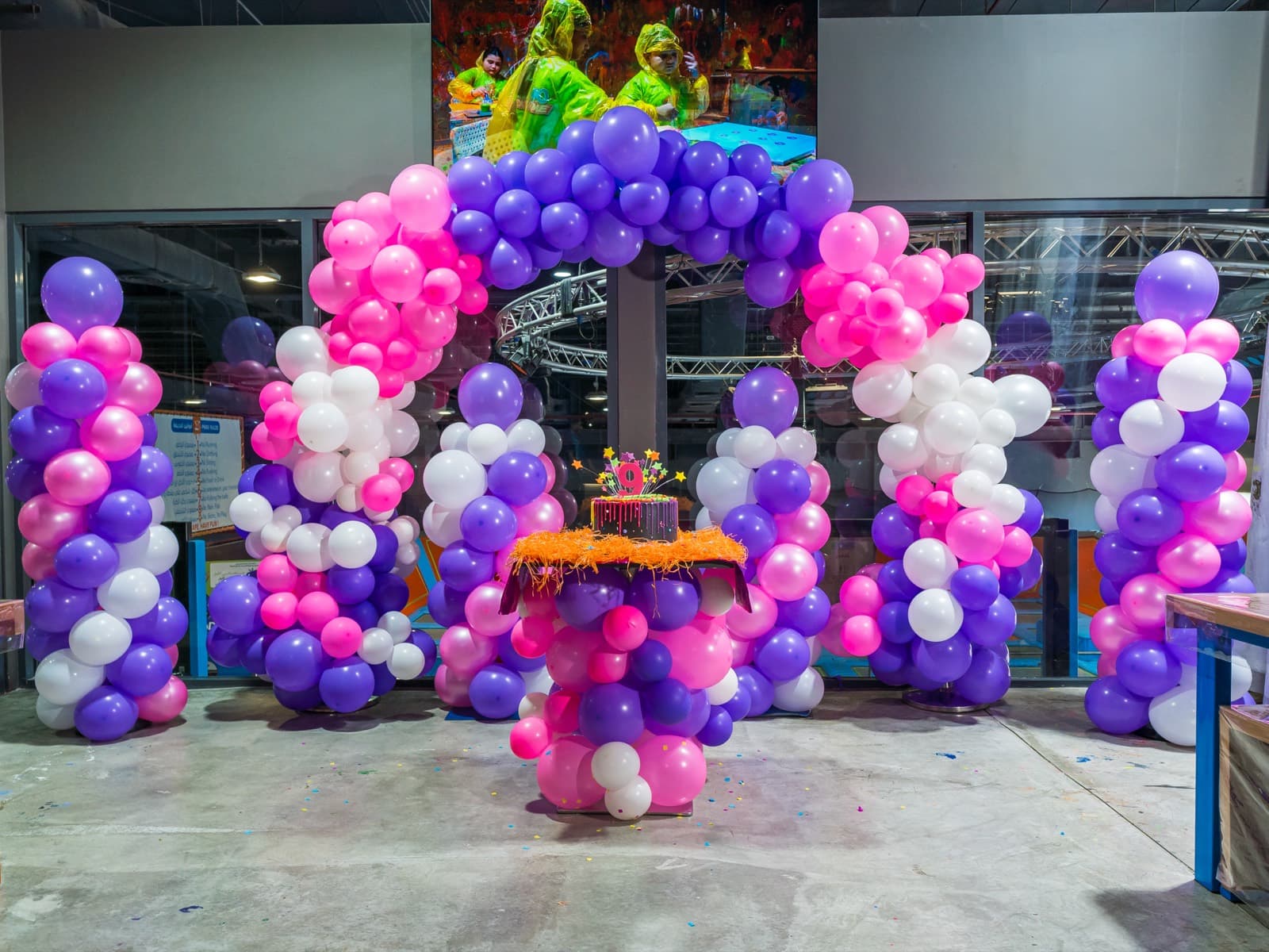Balloon arch and themed cake table ready before guests arrive