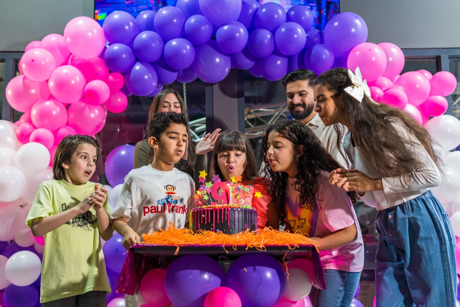 Birthday girl blowing out candles at her paint party