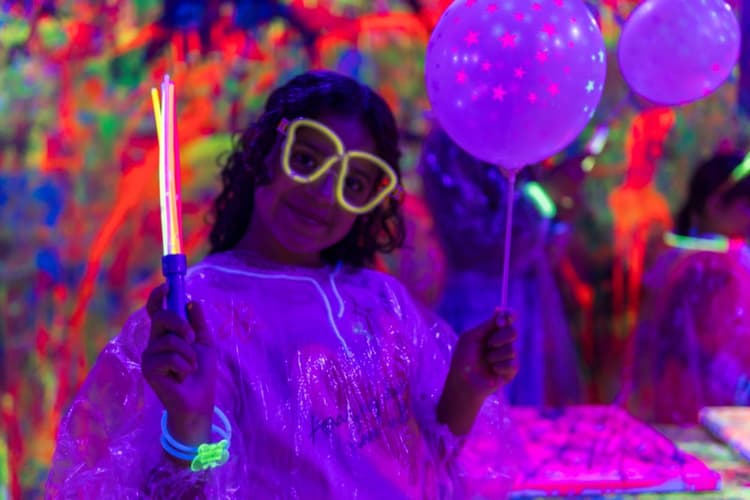 Girl with glow glasses and balloon at a UV party