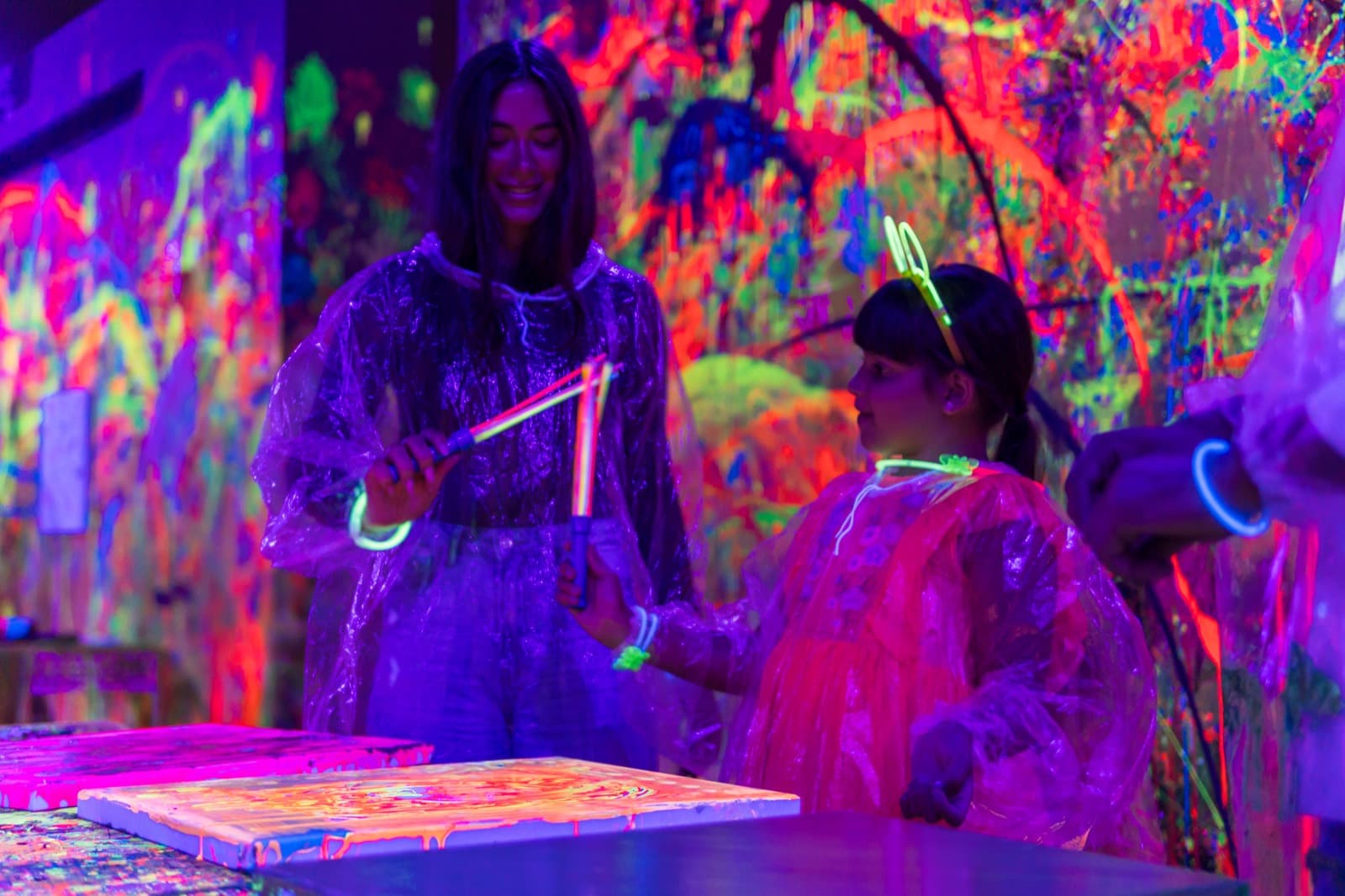Party host handing glow sticks to a young guest