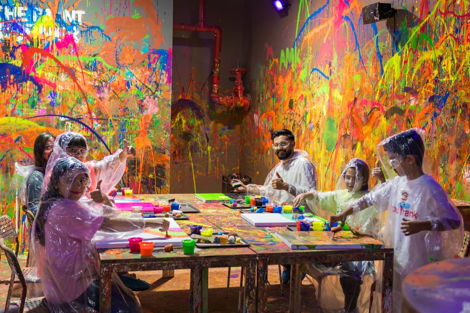 Guests painting at a glowing party table