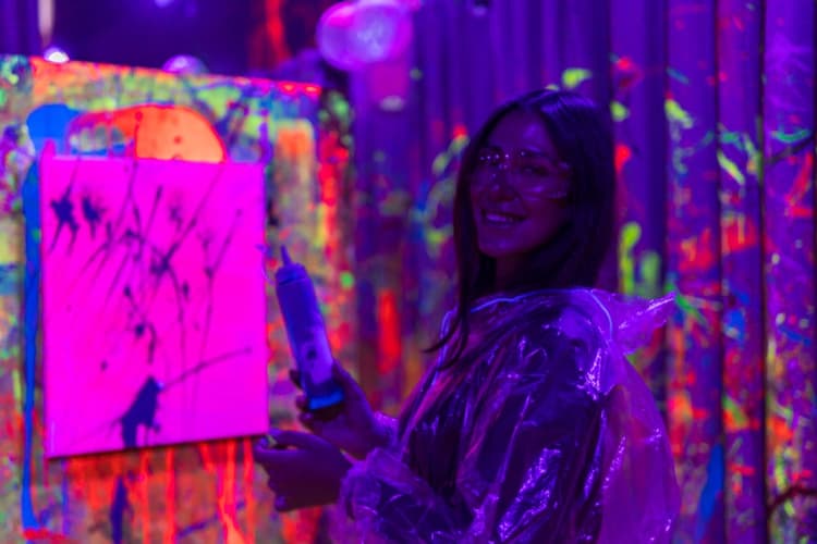 Smiling guest with goggles at a neon paint party