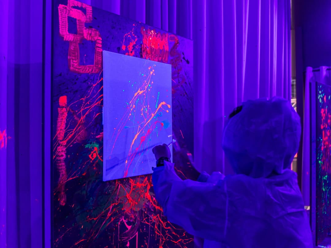 Kid painting at UV neon group session